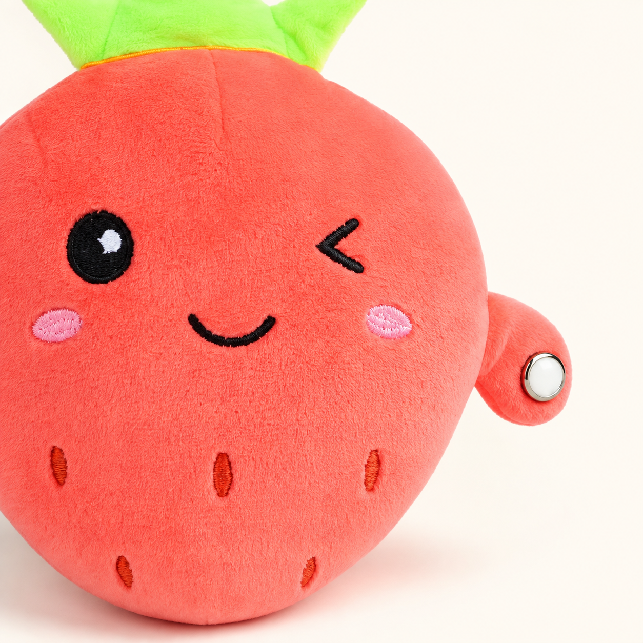 Close-up of the strawberry Plush Pal fabric, embroidery and metallic touch sensor